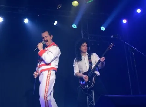 Eddie Devlin as Freddie Mercury on stage with the band's guitarist